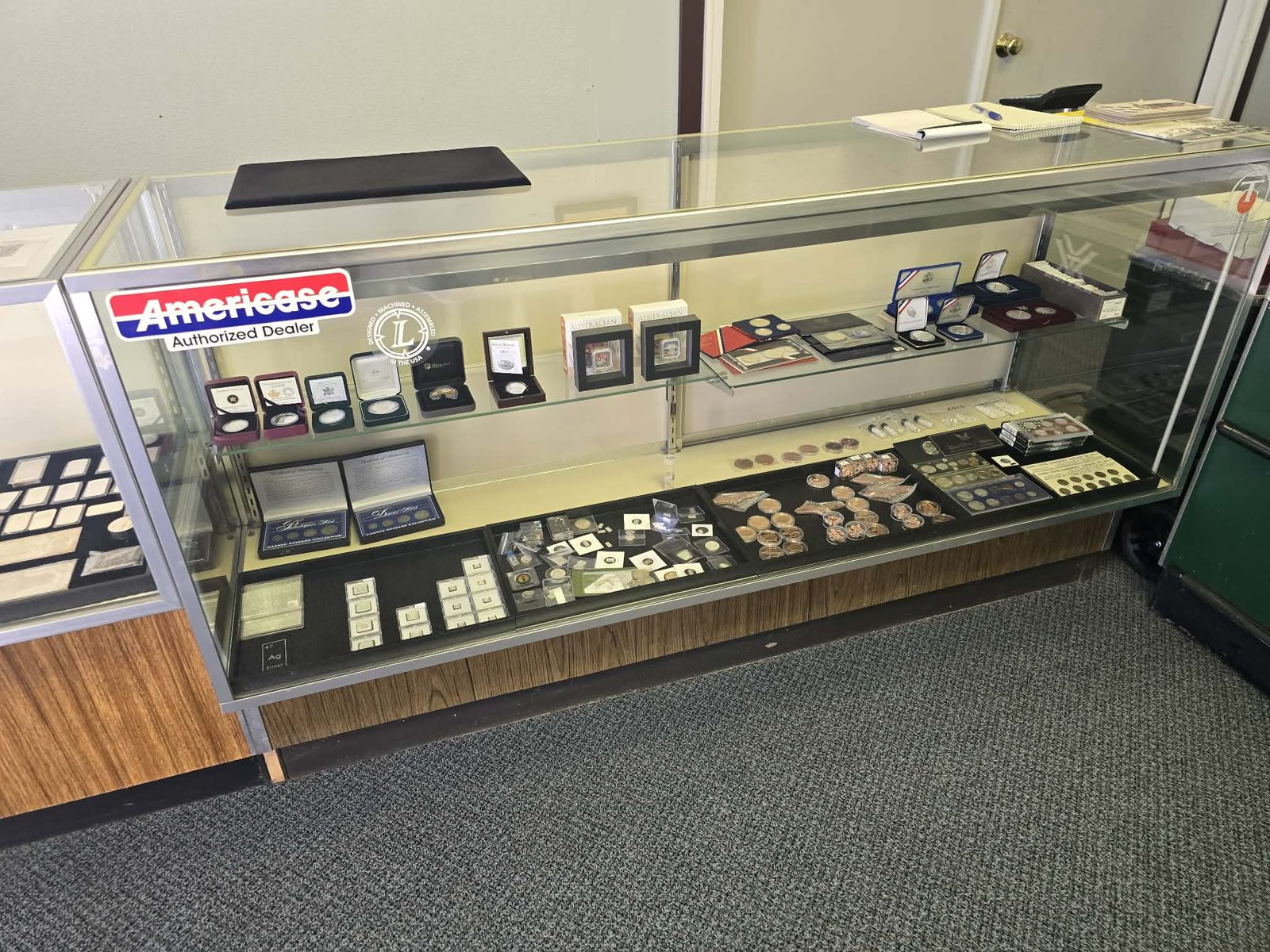 A display case at UP North Coins & Bullion with boxed silver coins, proof sets and bullion